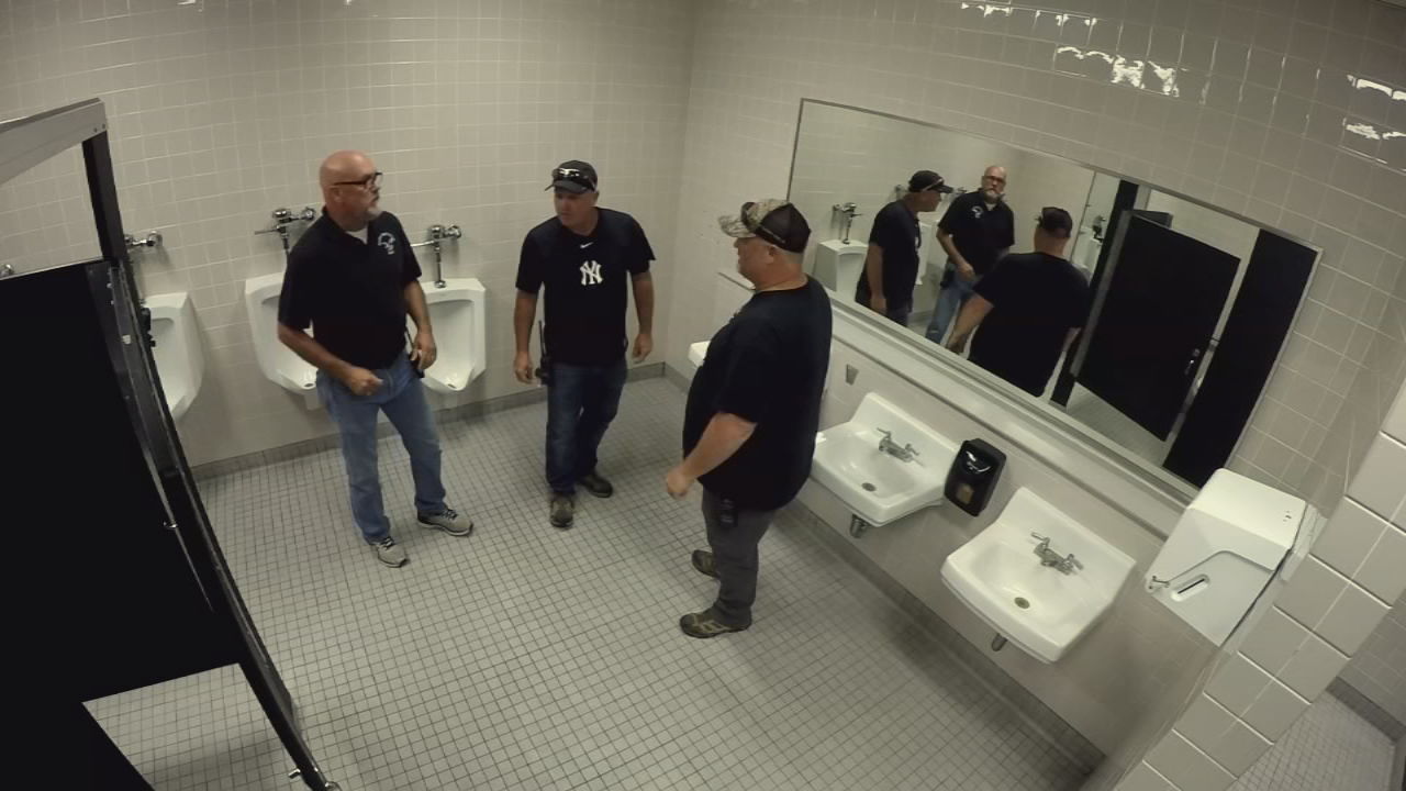 Musical maintenance workers in restroom